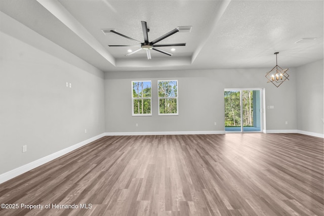 16113 Penn State Rd, Weeki Wachee, FL 34614 - empty room featuring wood finished floors, a raised ceiling, a chandelier, a textured ceiling, and ceiling fan