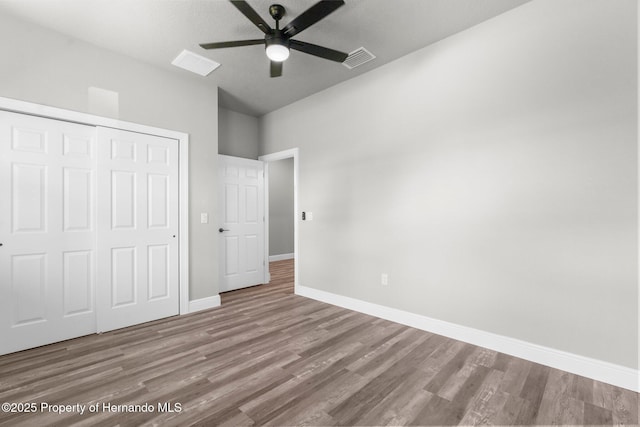 16113 Penn State Rd, Weeki Wachee, FL 34614 - unfurnished bedroom with a closet, wood finished floors, and ceiling fan