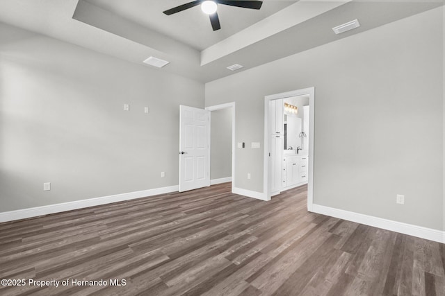 16113 Penn State Rd, Weeki Wachee, FL 34614 - empty room featuring wood finished floors, a ceiling fan, a raised ceiling, and a towering ceiling