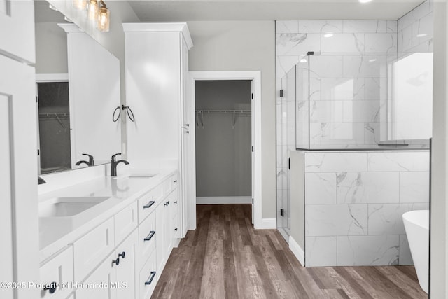 16113 Penn State Rd, Weeki Wachee, FL 34614 - full bathroom featuring double vanity, a shower stall, a walk in closet, and wood finished floors