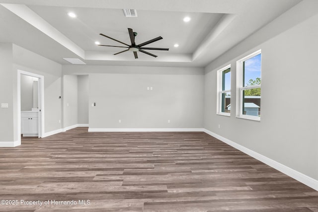 16113 Penn State Rd, Weeki Wachee, FL 34614 - spare room with a tray ceiling, ceiling fan, wood finished floors, and recessed lighting