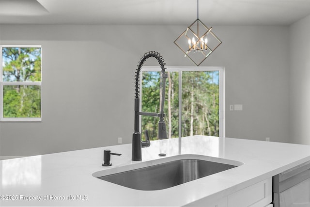 16113 Penn State Rd, Weeki Wachee, FL 34614 - kitchen with light countertops, white cabinetry, decorative light fixtures, a chandelier, and stainless steel dishwasher