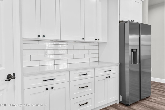 16113 Penn State Rd, Weeki Wachee, FL 34614 - kitchen featuring stainless steel fridge with ice dispenser, dark wood-style floors, light countertops, white cabinetry, and decorative backsplash