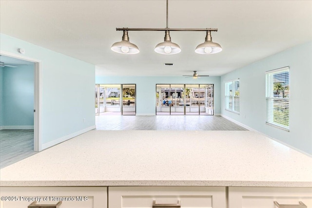 4016 Centavo Ct, Hernando Beach, FL 34607 - kitchen with ceiling fan, light stone countertops, open floor plan, decorative light fixtures, and wood finished floors