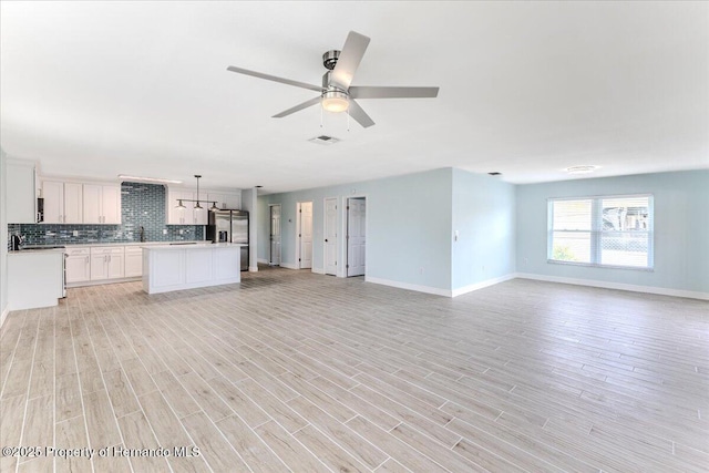4016 Centavo Ct, Hernando Beach, FL 34607 - unfurnished living room with light wood finished floors and a ceiling fan
