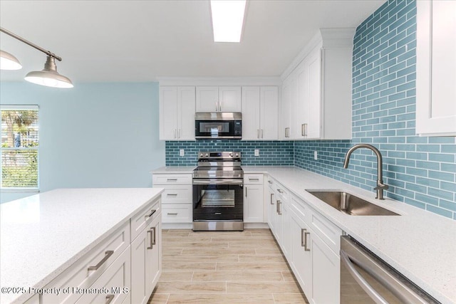 4016 Centavo Ct, Hernando Beach, FL 34607 - kitchen with appliances with stainless steel finishes, decorative backsplash, white cabinets, and light wood-type flooring