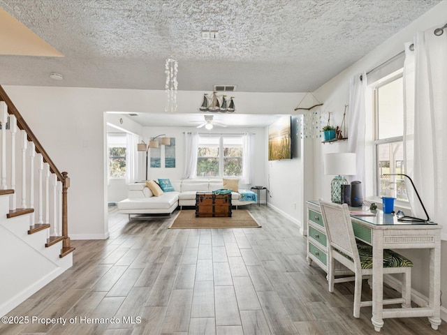 3579 Eagle Nest Dr, Hernando Beach, FL 34607 - living area featuring a ceiling fan, a textured ceiling, stairway, and wood finished floors