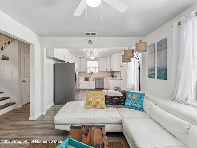 3579 Eagle Nest Dr, Hernando Beach, FL 34607 - living room with stairs, a ceiling fan, and light wood-style flooring