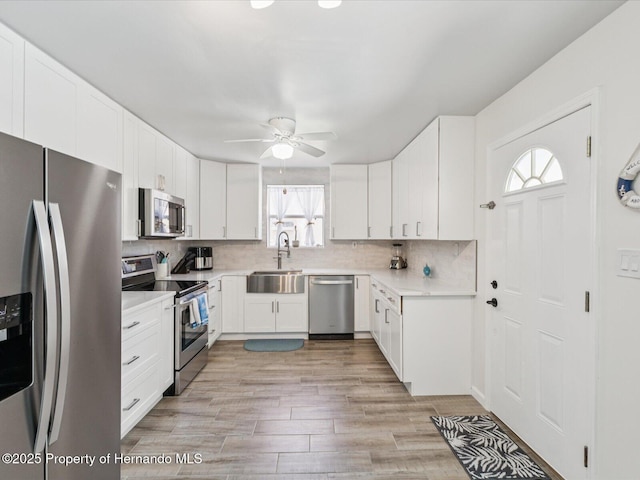 3579 Eagle Nest Dr, Hernando Beach, FL 34607 - kitchen featuring appliances with stainless steel finishes, tasteful backsplash, a ceiling fan, white cabinets, and light countertops