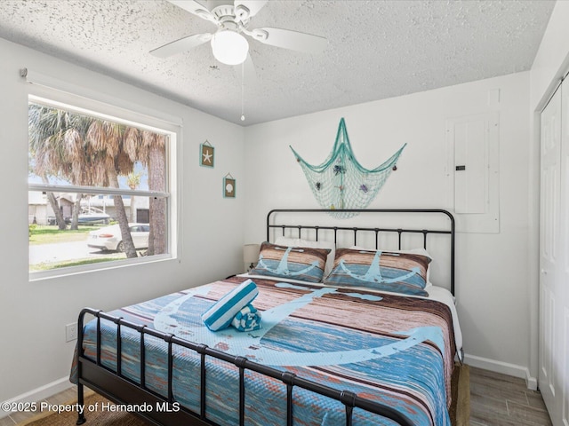 3579 Eagle Nest Dr, Hernando Beach, FL 34607 - bedroom with electric panel, a textured ceiling, wood finished floors, and a ceiling fan