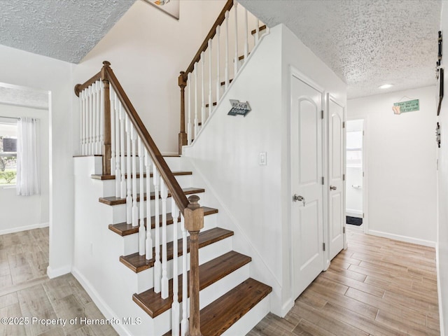3579 Eagle Nest Dr, Hernando Beach, FL 34607 - staircase featuring a textured ceiling and wood finished floors