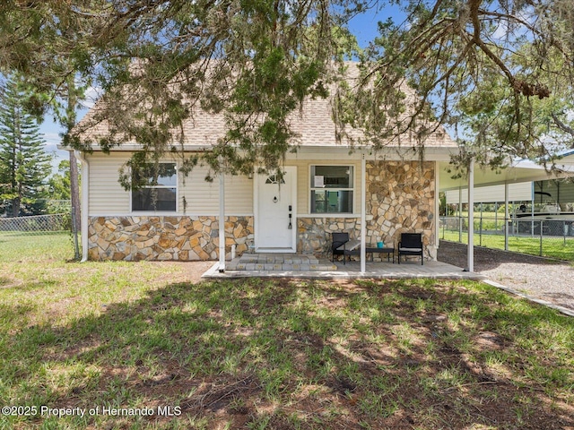 3579 Eagle Nest Dr, Hernando Beach, FL 34607 - view of front of property with stone siding, a porch, and roof with shingles