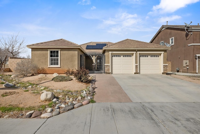 view of front of house with solar panels, concrete driveway, an attached garage, stone siding, and stucco siding