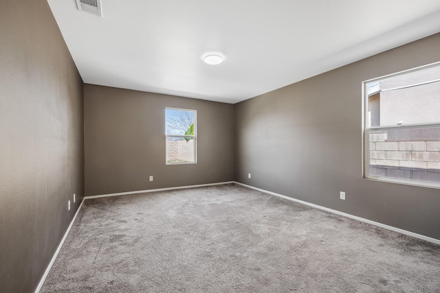 empty room with baseboards, carpet, and visible vents