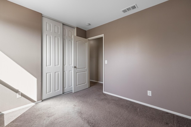 unfurnished bedroom with visible vents, carpet flooring, baseboards, and a closet