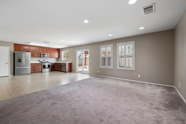unfurnished living room with visible vents, recessed lighting, baseboards, and a wealth of natural light