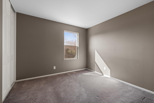 carpeted spare room featuring baseboards