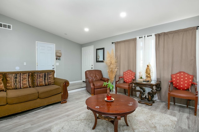 living room featuring light hardwood / wood-style flooring and lofted ceiling