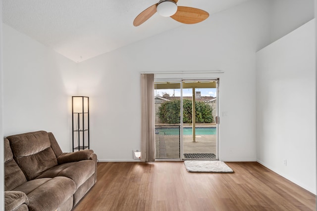 unfurnished living room featuring ceiling fan, baseboards, high vaulted ceiling, and wood finished floors