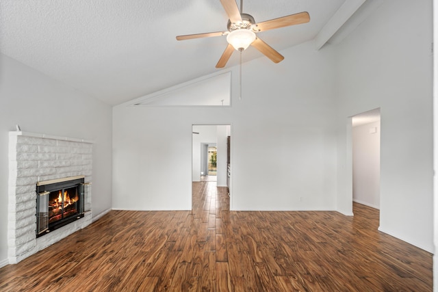 unfurnished living room featuring lofted ceiling, a ceiling fan, wood finished floors, baseboards, and a brick fireplace