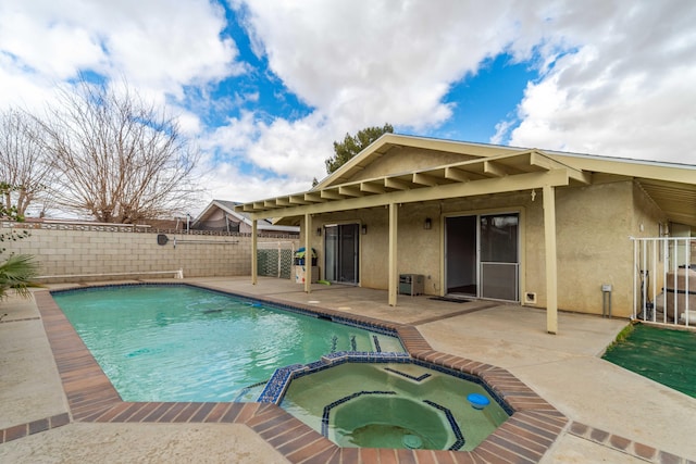 view of pool with a pool with connected hot tub, a patio, and fence