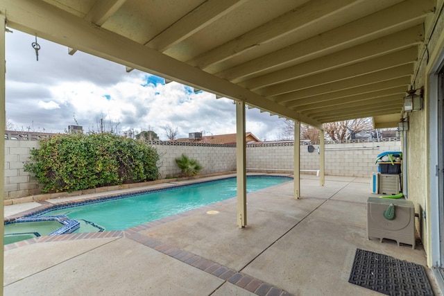 view of swimming pool with a patio, a fenced backyard, and a pool with connected hot tub