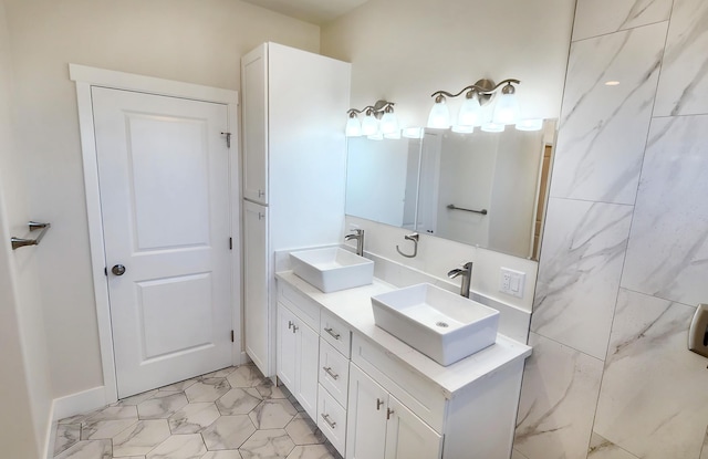 bathroom featuring marble finish floor, double vanity, and a sink