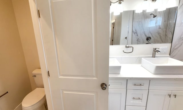 bathroom featuring double vanity, a sink, toilet, and walk in shower