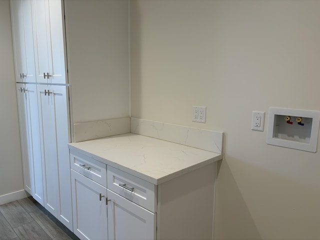 laundry room featuring dark wood-style floors, cabinet space, and hookup for a washing machine