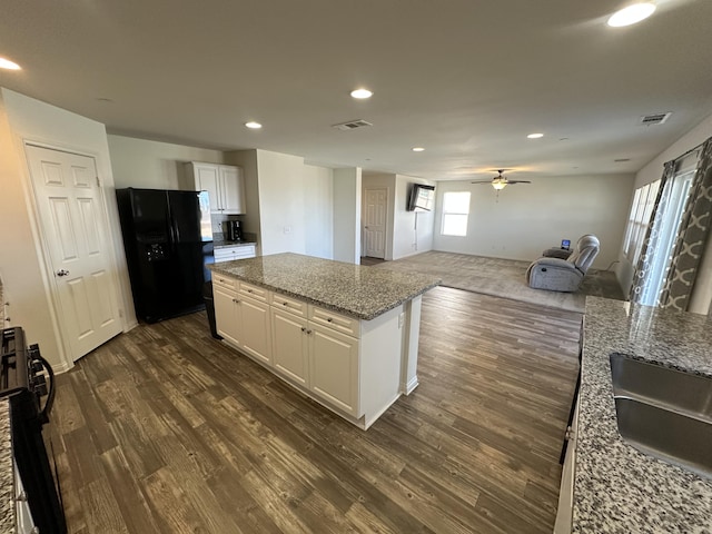 kitchen featuring a kitchen island, black fridge with ice dispenser, dark wood-style flooring, and white cabinetry