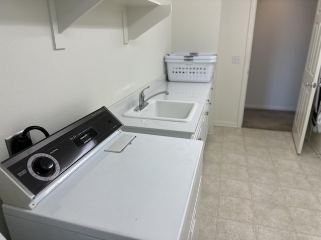 laundry area with cabinet space, washer / clothes dryer, and a sink