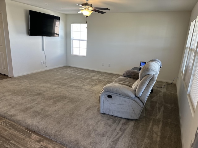 living area featuring baseboards, carpet floors, and ceiling fan