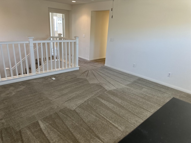 unfurnished room with baseboards and carpet flooring