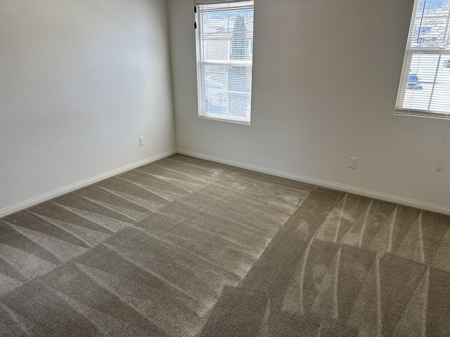 spare room featuring baseboards and carpet floors