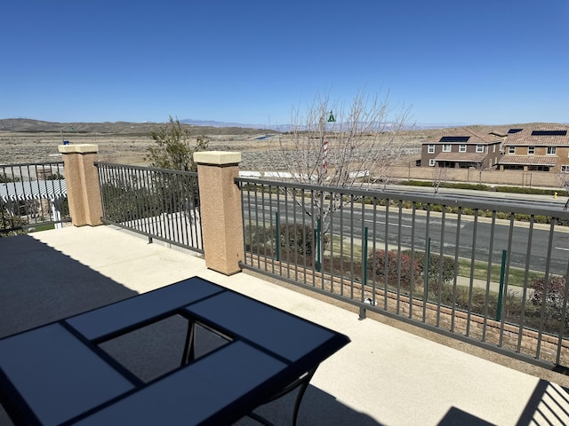 view of patio with a mountain view and a balcony