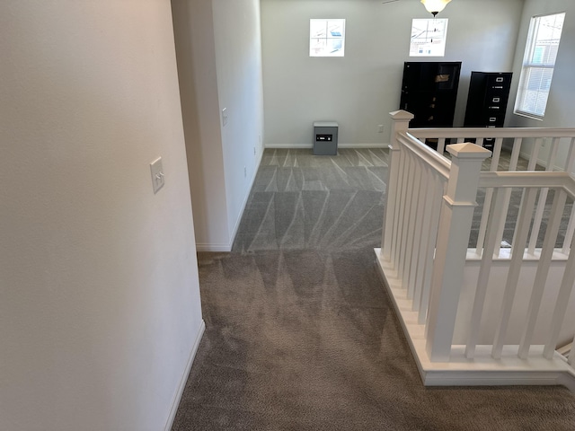 corridor with carpet flooring, an upstairs landing, and baseboards