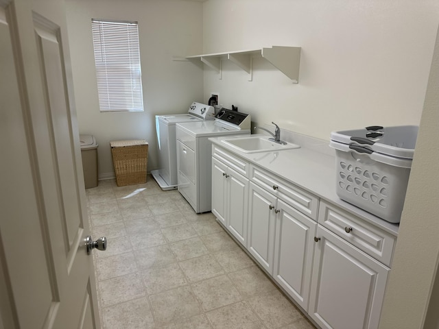 laundry area with a sink, cabinet space, baseboards, and washing machine and clothes dryer