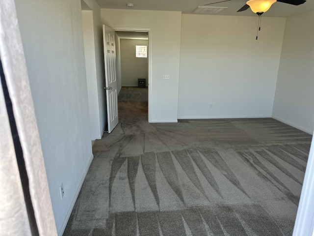 unfurnished room with visible vents, baseboards, carpet floors, and ceiling fan