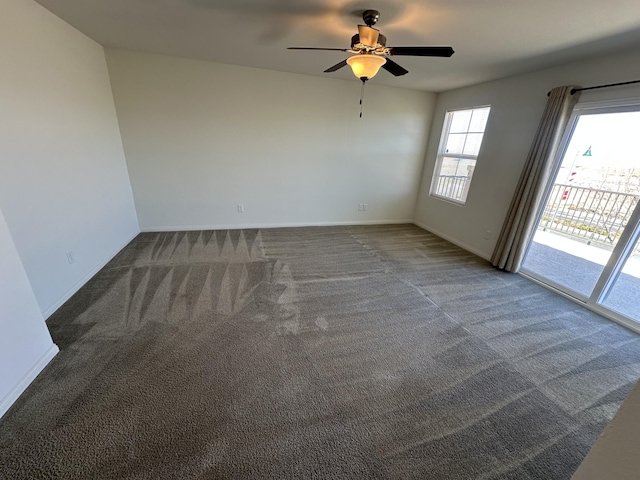 carpeted empty room featuring plenty of natural light, a ceiling fan, and baseboards