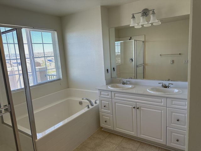 full bath with a bath, a stall shower, double vanity, and a sink