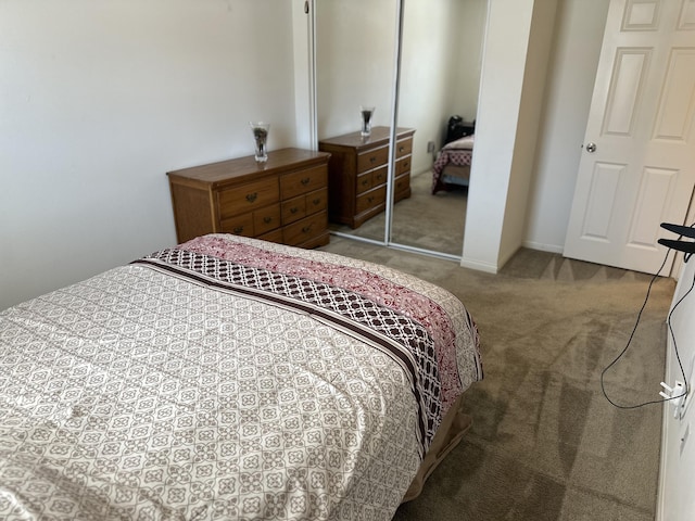 carpeted bedroom with baseboards and a closet