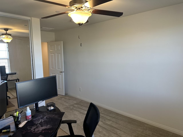 office space with light colored carpet, baseboards, and ceiling fan