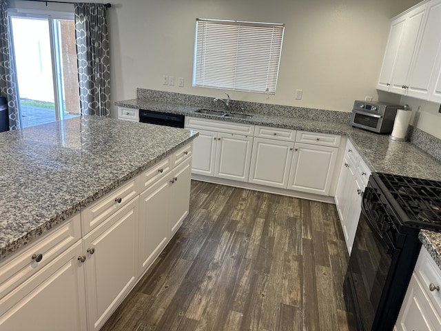 kitchen with light stone counters, dark wood-style floors, white cabinets, black appliances, and a sink