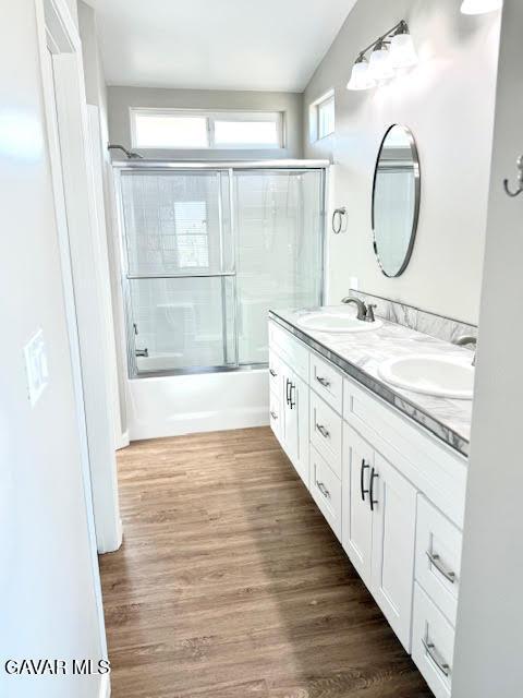 3503 Glenridge Ave, Rosamond, CA 93560 - bathroom featuring double vanity, shower / bath combination with glass door, wood finished floors, and lofted ceiling