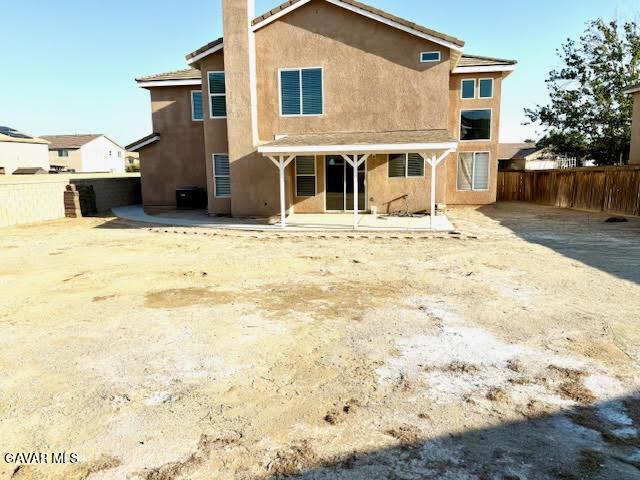 3503 Glenridge Ave, Rosamond, CA 93560 - back of property with stucco siding, a fenced backyard, a patio area, and a chimney