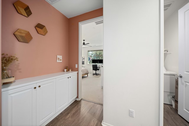 corridor featuring washer / dryer, dark wood-style flooring, and visible vents