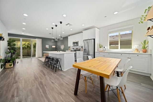 dining area with a wealth of natural light, visible vents, light wood finished floors, and recessed lighting