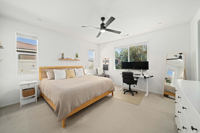 bedroom with a ceiling fan, visible vents, light carpet, and baseboards