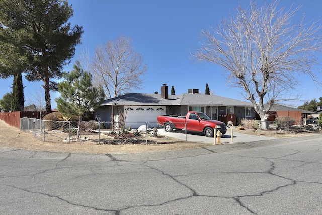 single story home with an attached garage, a fenced front yard, and concrete driveway