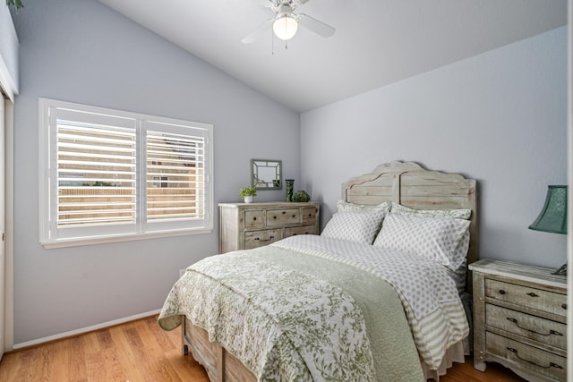 bedroom featuring ceiling fan, light hardwood / wood-style flooring, and lofted ceiling